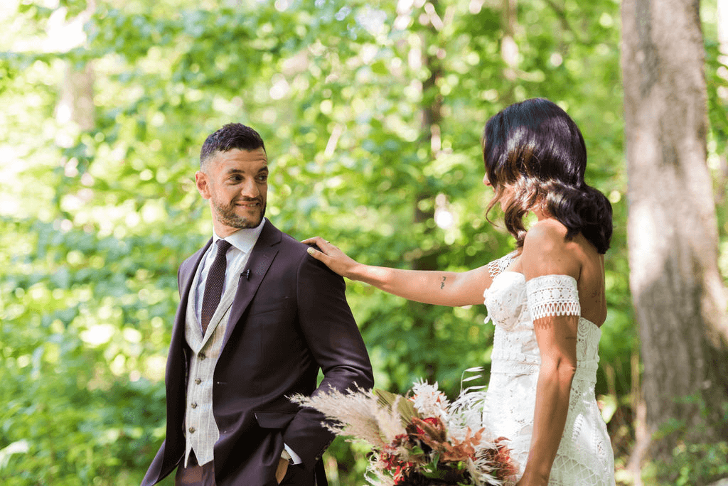 Bride taps on groom's shoulder as they do first looks