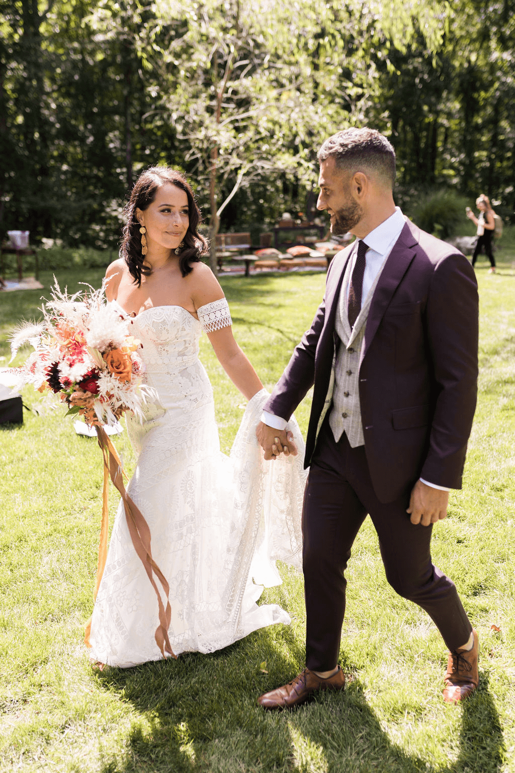 Bride and groom hold hands as they walk