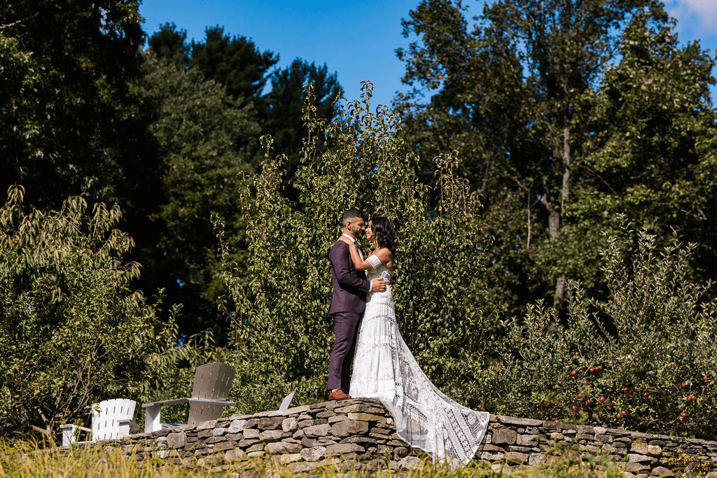 Bride and groom photographed at a distance on top of wooden wall