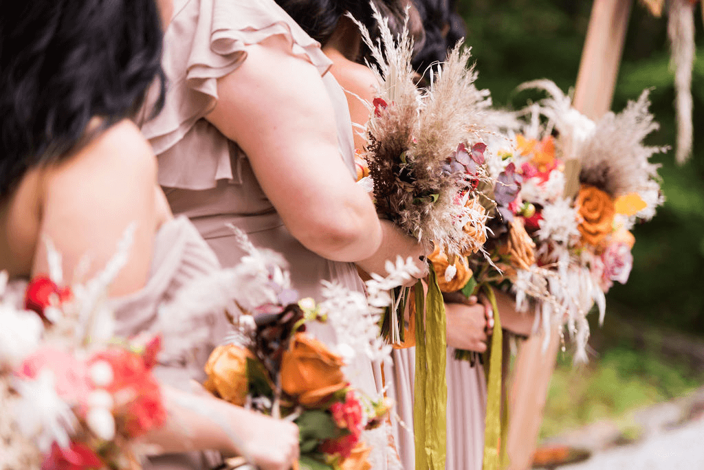 Close up of women lined up holding bouquet of flowers