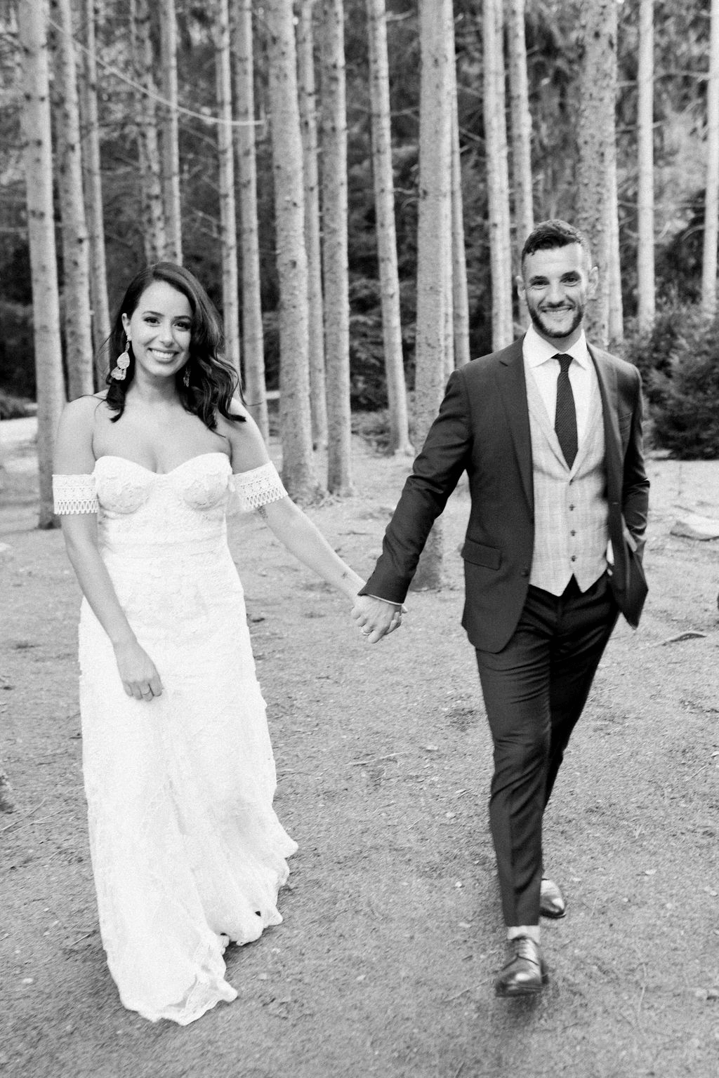 Bride and groom hold hands while walking