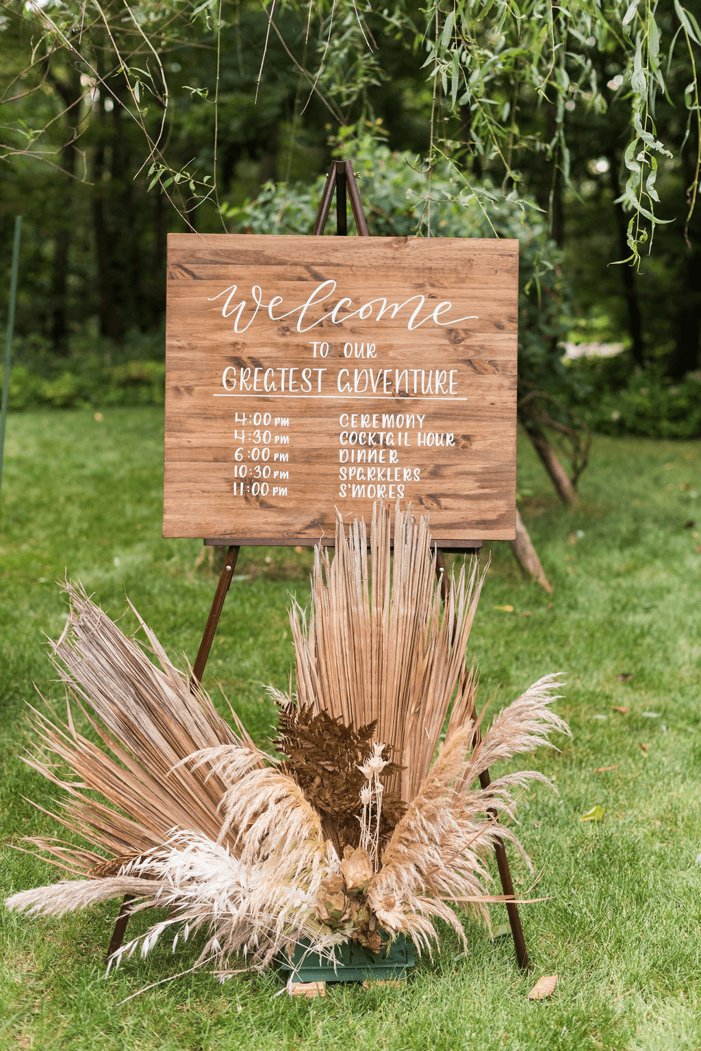 A wooden welcome sign in white script