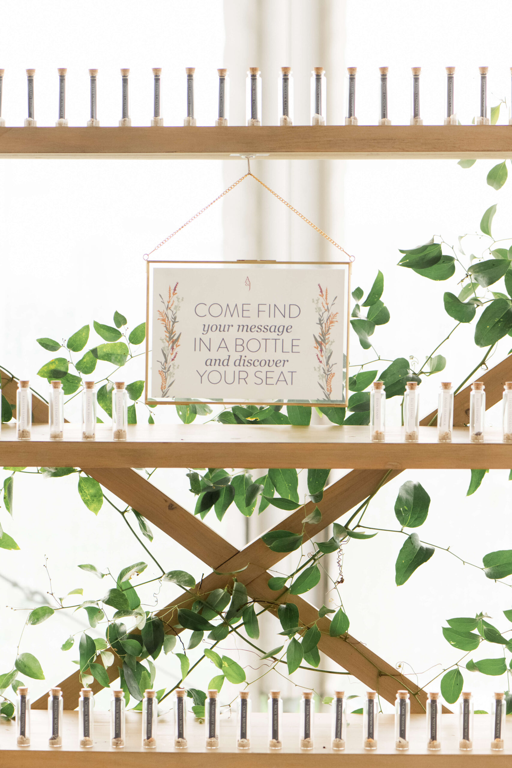 Seating chart with guests named in small bottles with shells and sand